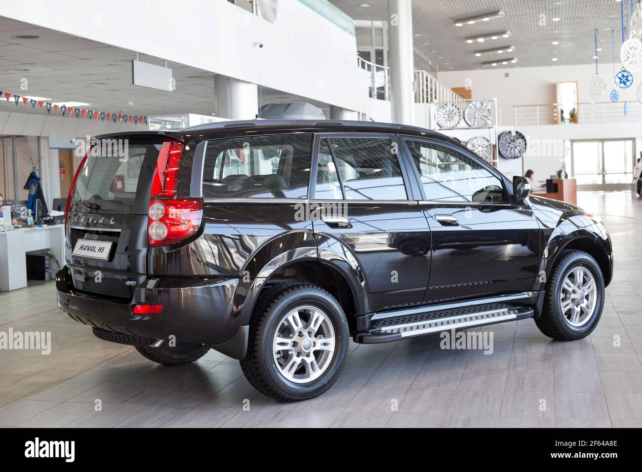 Russia, Izhevsk - February 17, 2021: Haval showroom. New modern Haval H5 car in dealer showroom. Back and side view. Car manufacturer from China. Stock Photo