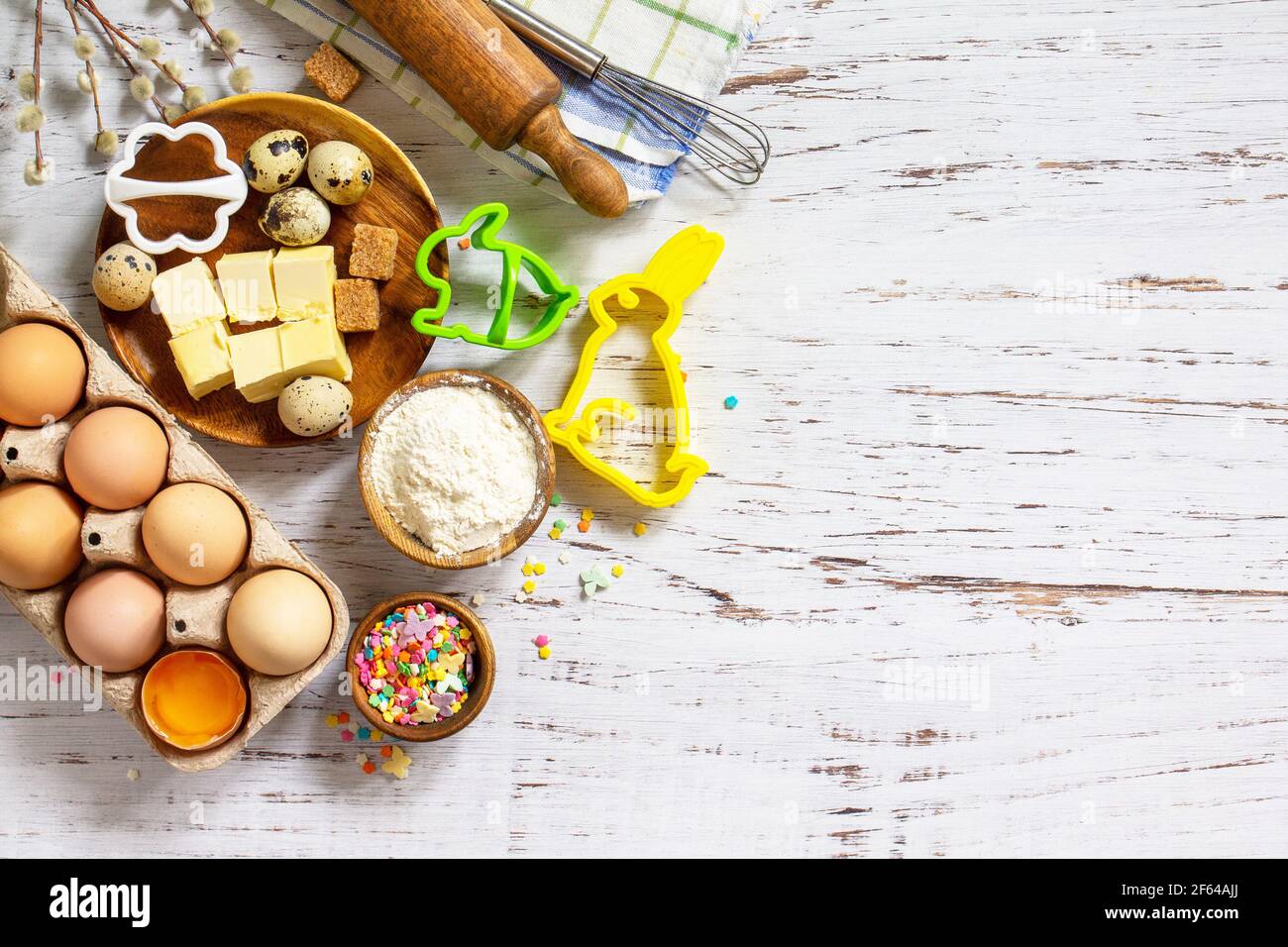 Baking or cooking background frame. Ingredients, kitchen items for Easter festive baking. Kitchen utensils, flour, brown sugar, eggs, butter, confetti Stock Photo