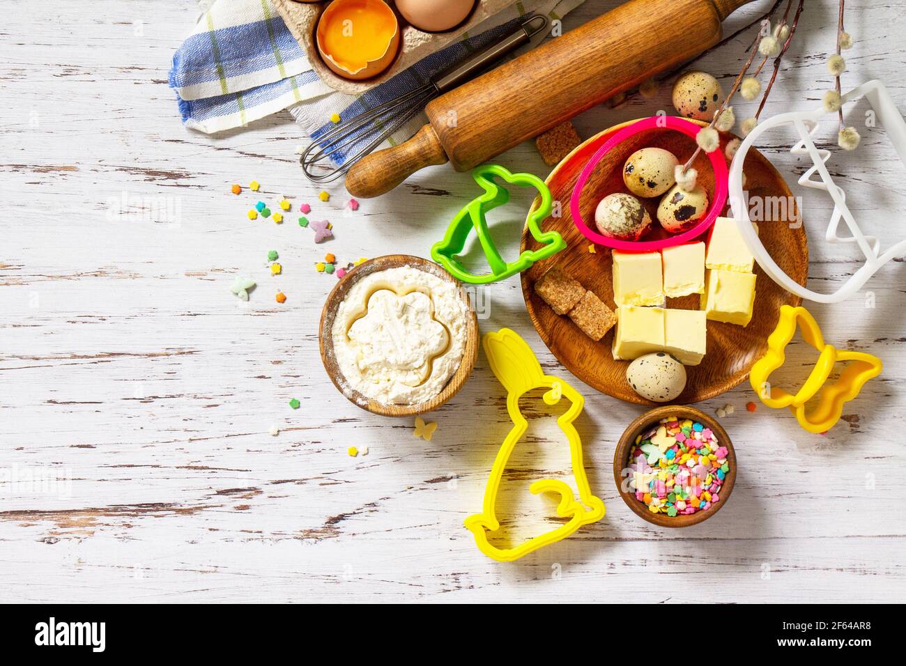 Baking or cooking background frame. Ingredients, kitchen items for Easter festive baking. Kitchen utensils, flour, brown sugar, eggs, butter, confetti Stock Photo