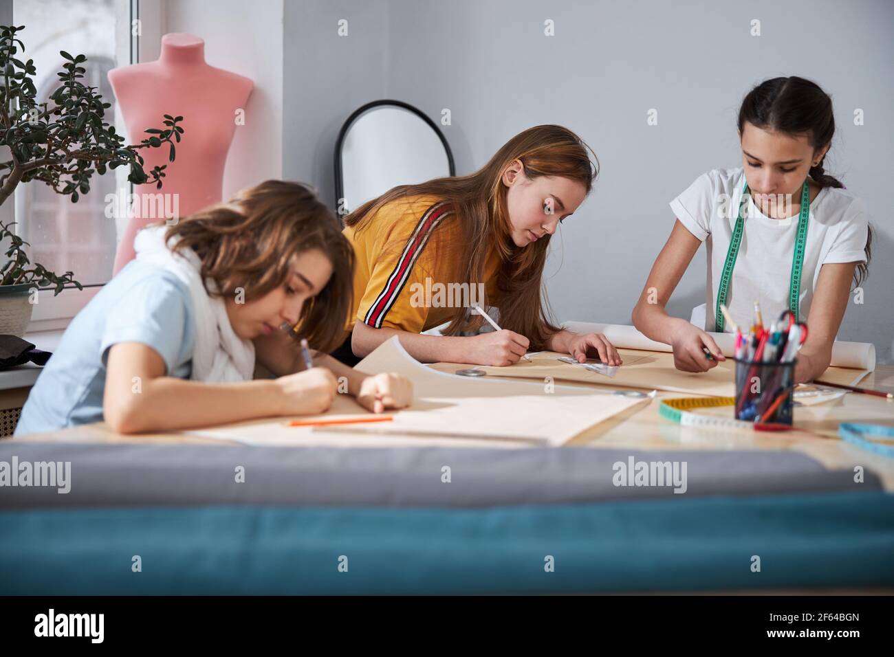 Charming girls drafting sewing patterns in Stock Photo Alamy