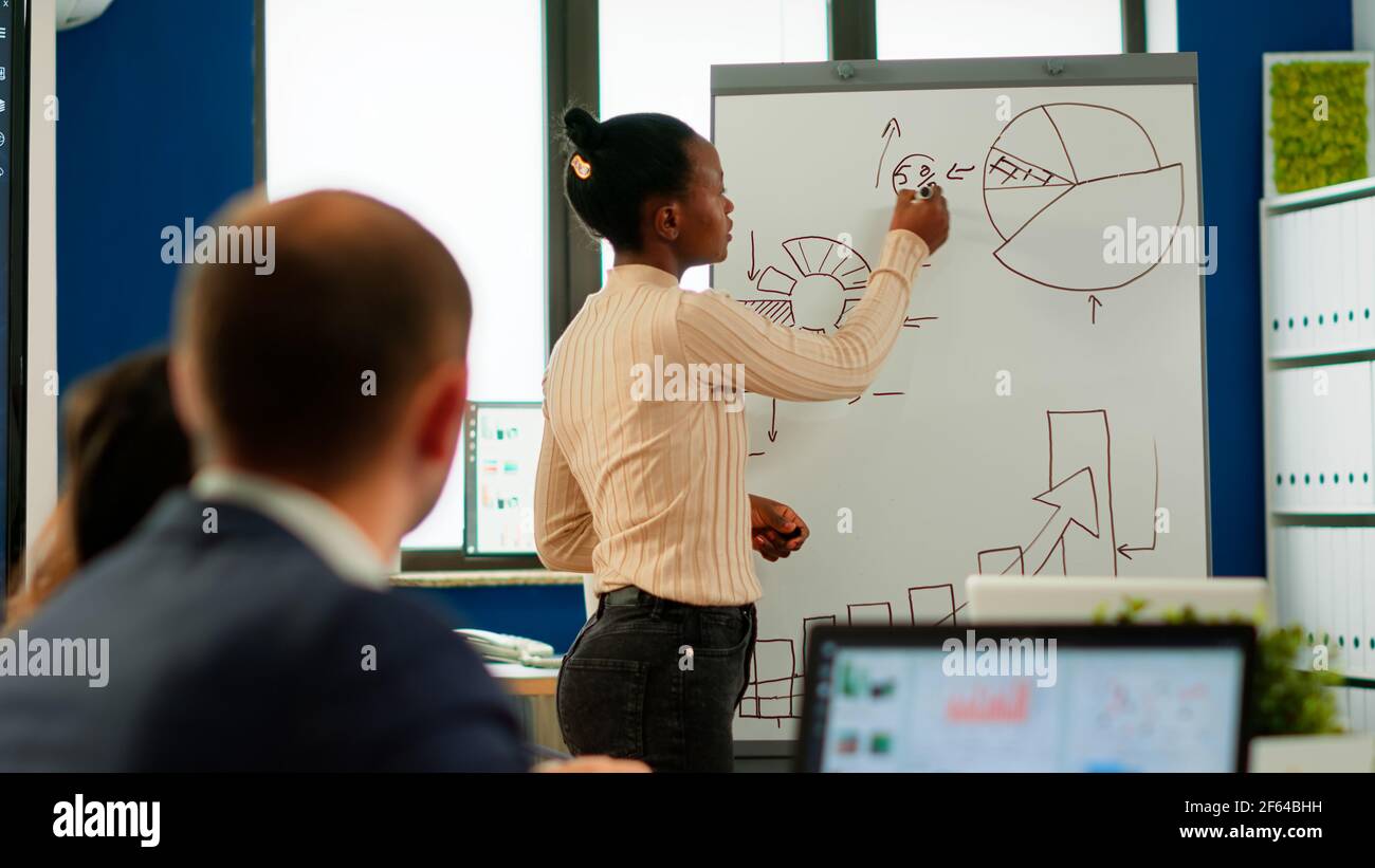 African american manager giving tasks for businesspeople in office ...