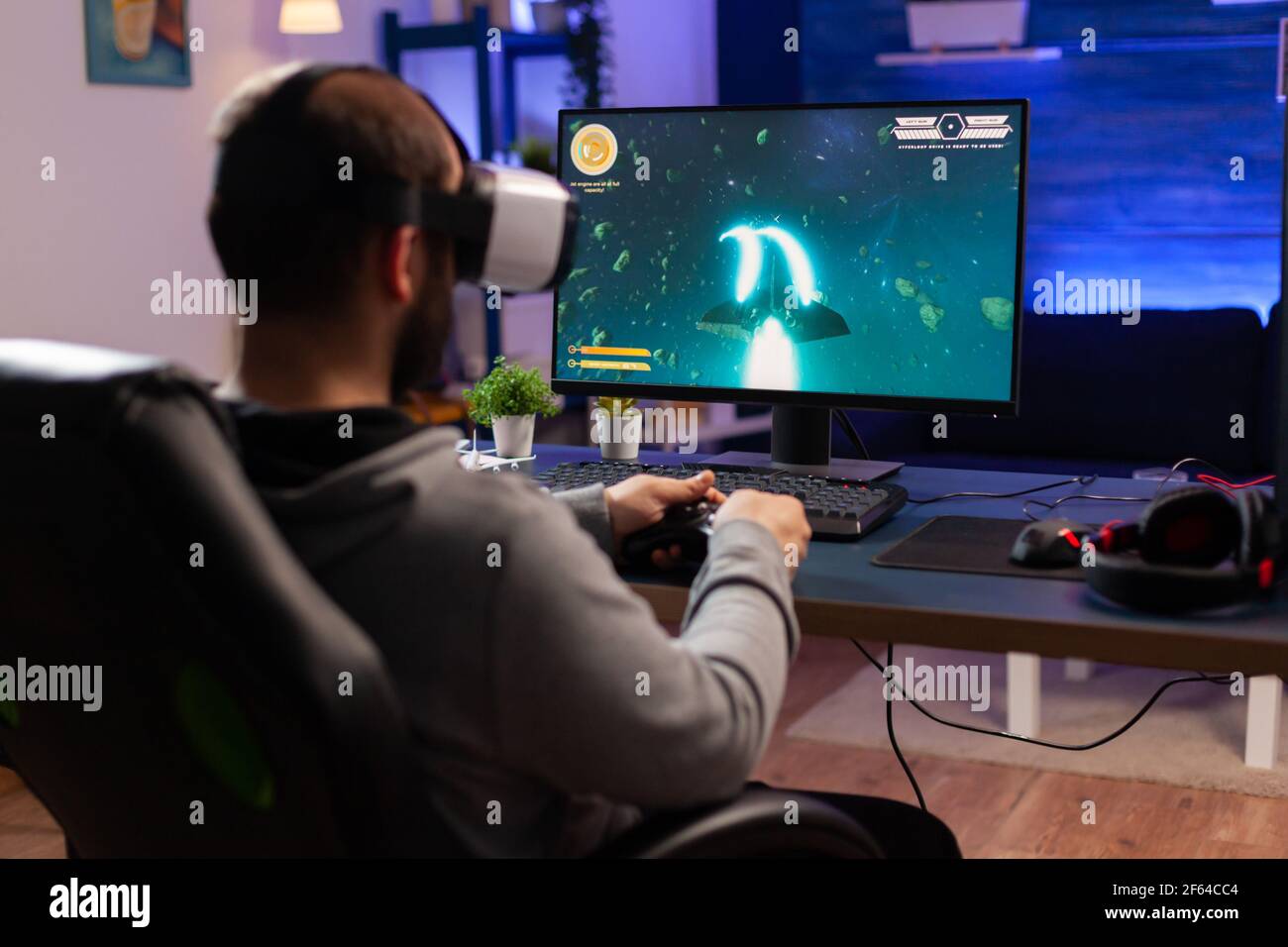 Professional gamer wearing virtual realilty headset and playing space shooter video games with controller
