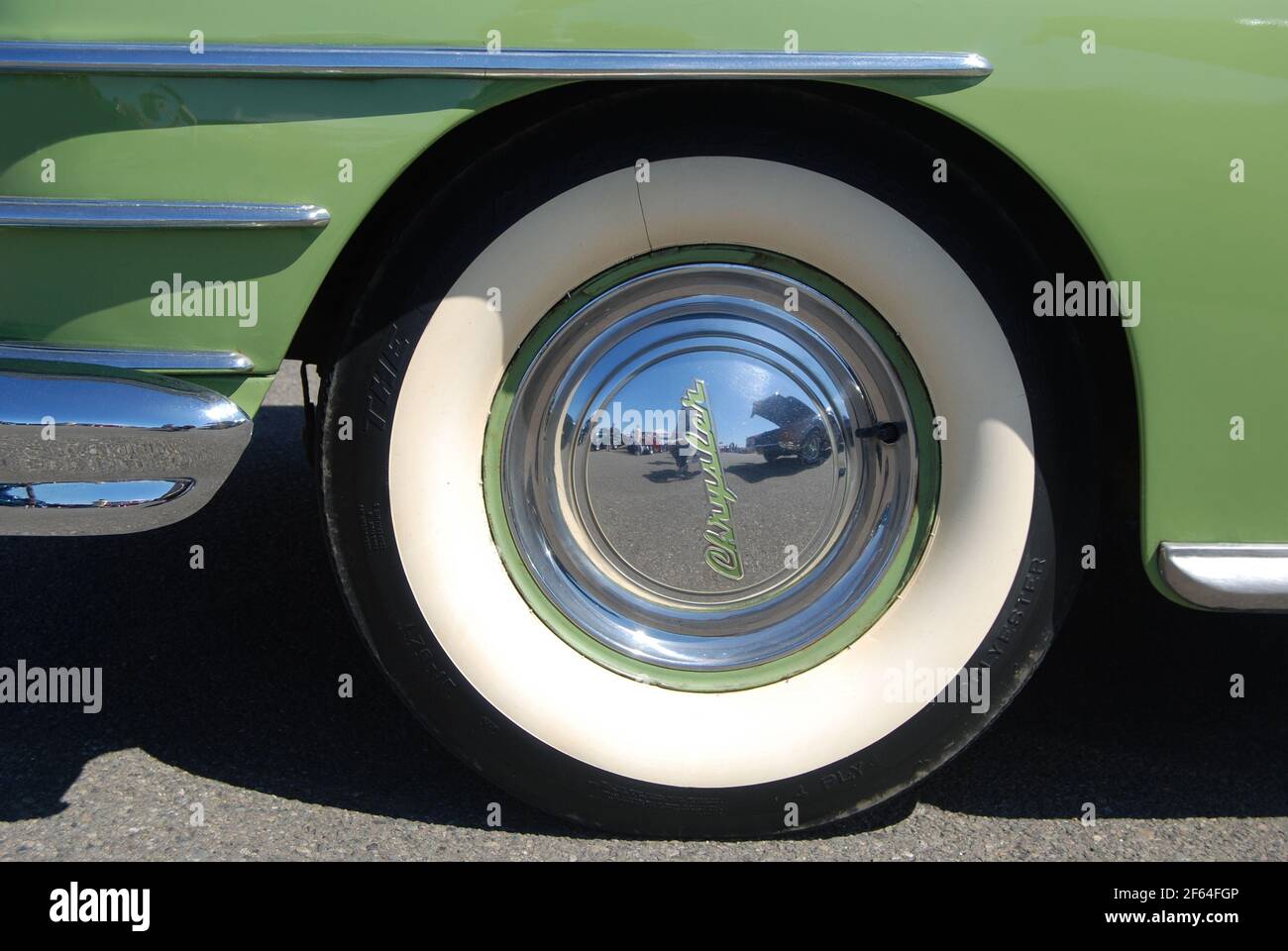 1947 Chrysler Coupe whitewall tires with shiny chrome hubcap detail. Stock Photo