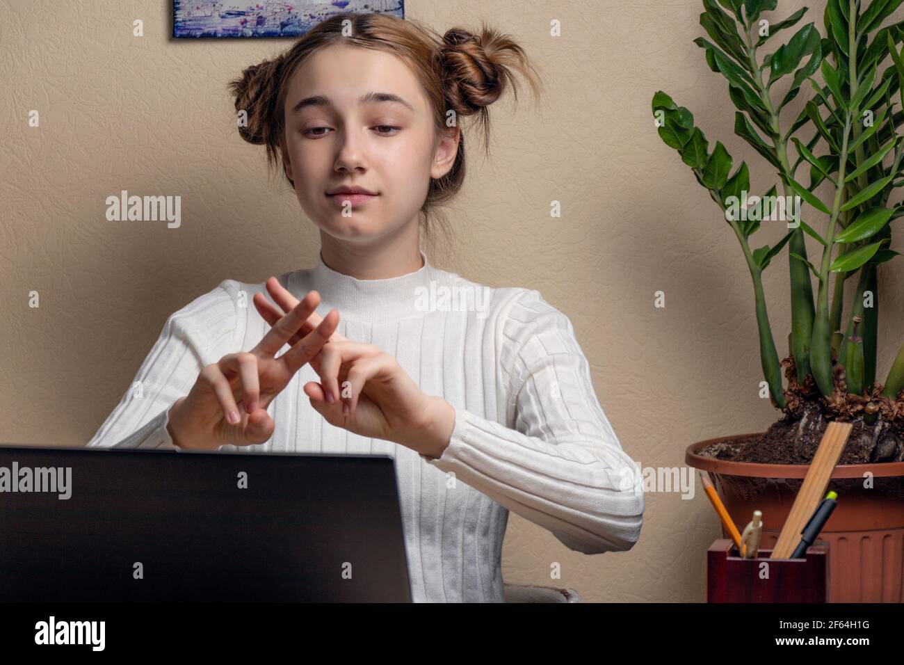 teenage girl deaf disabled child school girl learning online class on laptop communicating with teacher by video conference call using sign language s Stock Photo