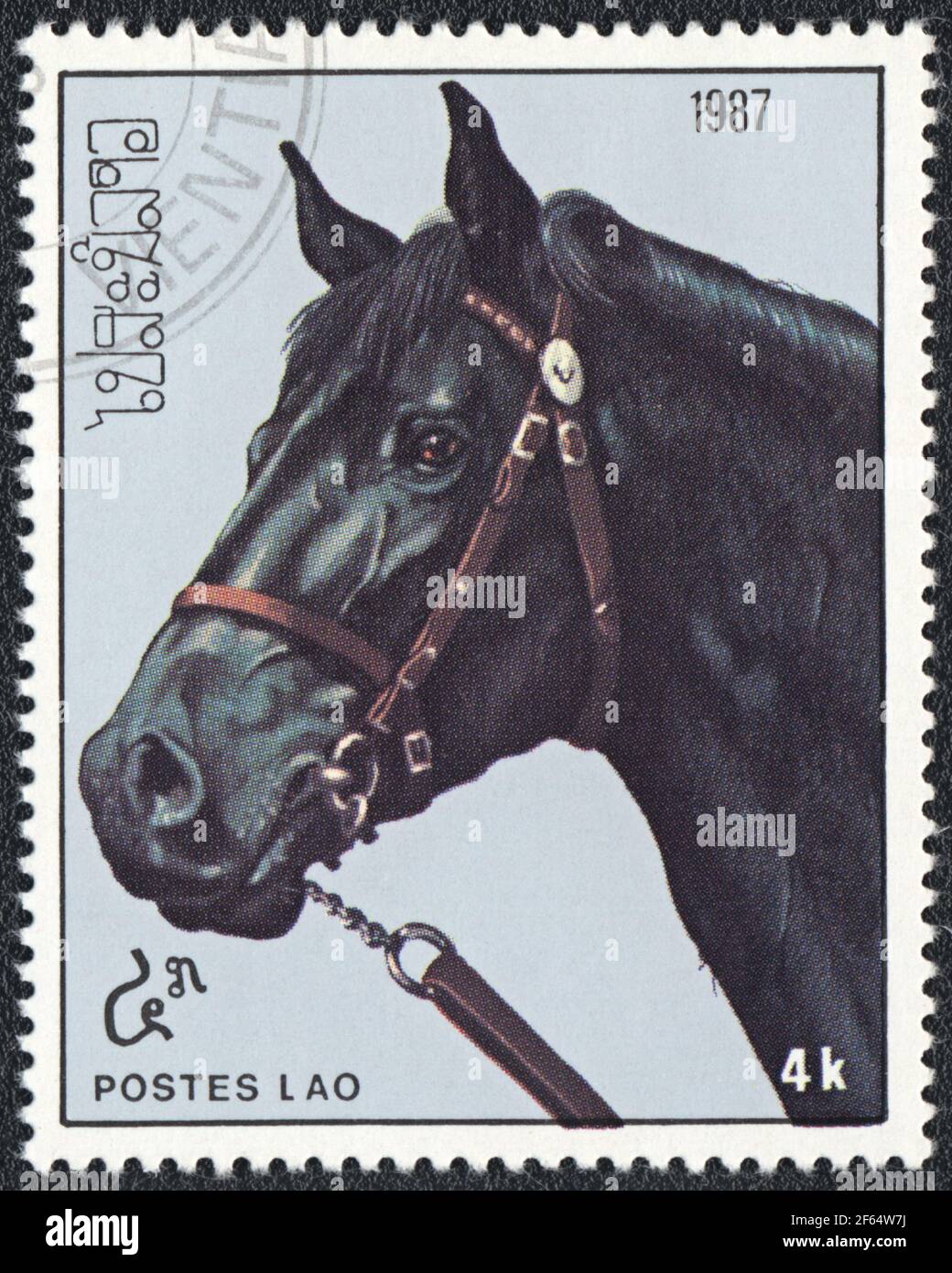 A postage stamp shows a black horse (Equus ferus caballus) from series: Thoroughbred Horses, Laos, 1987 Stock Photo