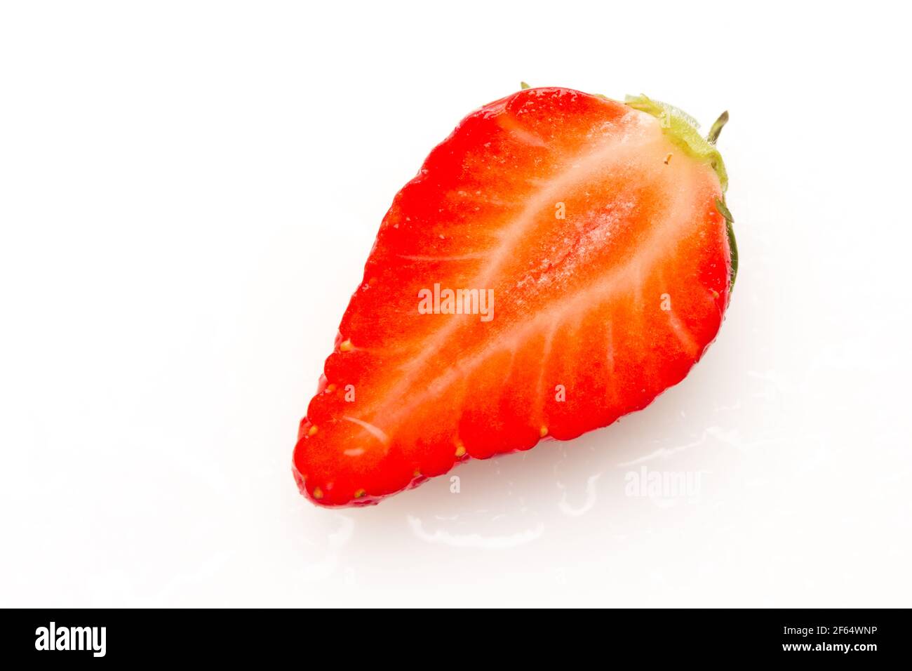 Close-ups of seasonal strawberries on white background. Strawberries with their green leaves and water drops. Macro photograph of strawberry fruit see Stock Photo