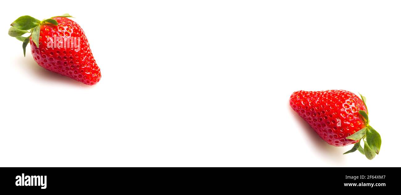 Close-ups of seasonal strawberries on white background. Strawberries with their green leaves and water drops. Macro photograph of strawberry fruit see Stock Photo