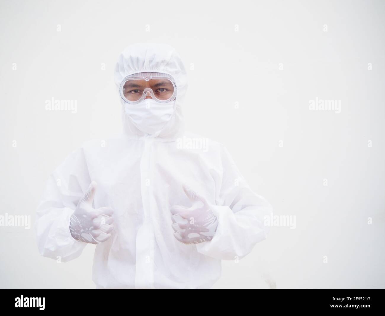 Asian male doctor or scientist in PPE suite uniform showing thumbs up. coronavirus or COVID-19 concept isolated white background Stock Photo