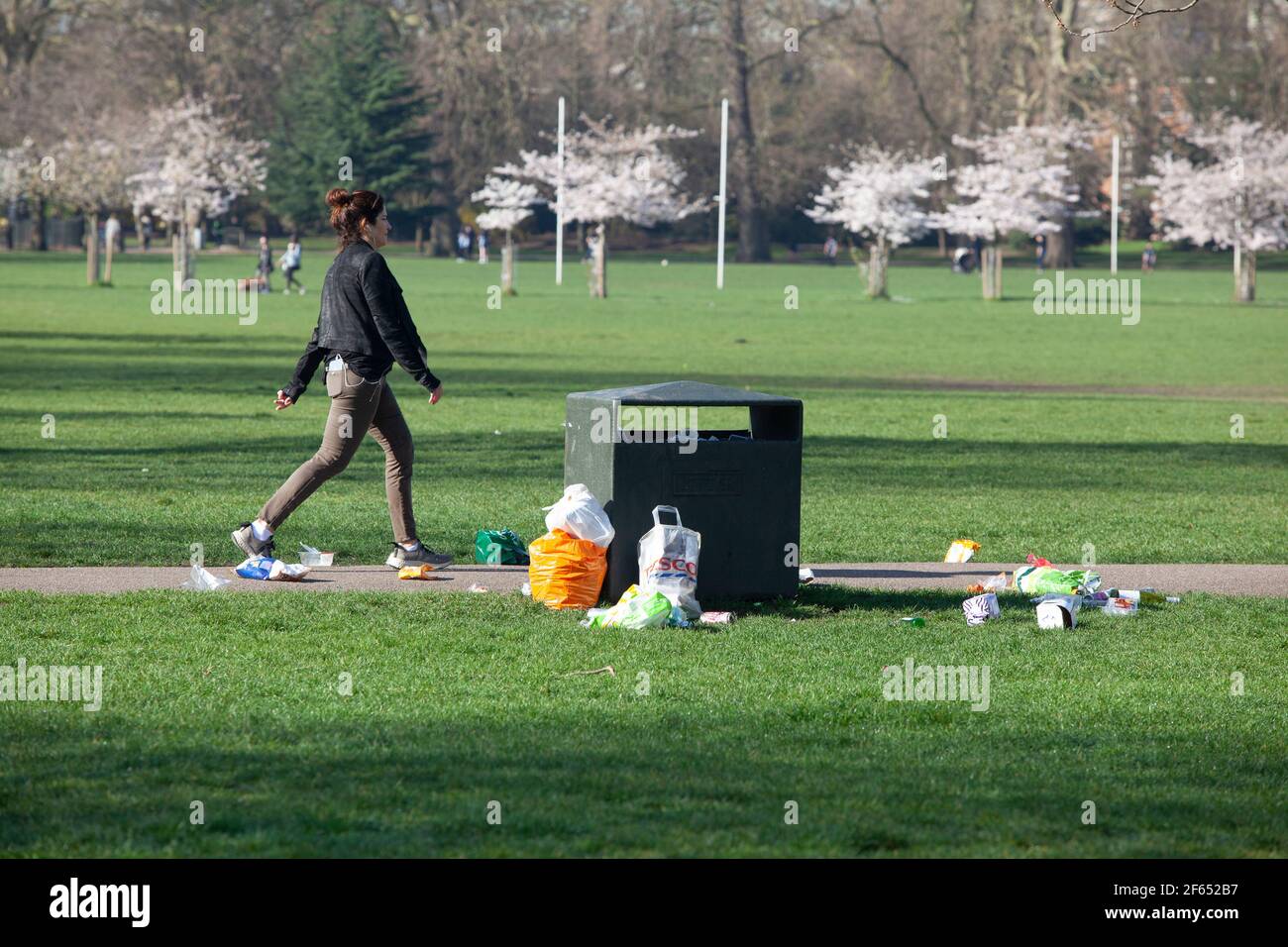 UK weather, London, 30 March 2021: In Battersea Park after one day of lock down rules being relaxed litter has accumulated by an over-flowing bin. Councils around the country are expecting extra pressure on public spaces throughout the summer. Anna Watson/Alamy Live News Stock Photo