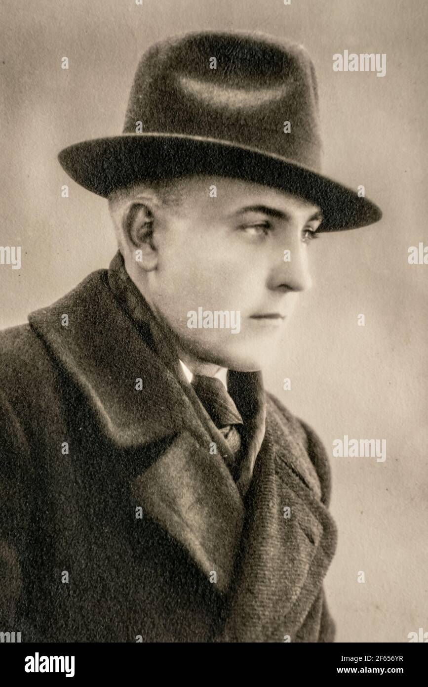 Germany - CIRCA 1930s: Man wearing coat and hat portrait in studio art deco era Vintage photo. Close up Stock Photo