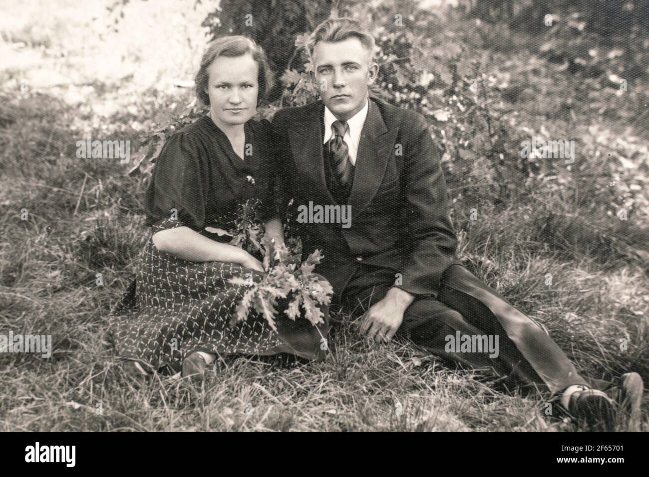 Germany - CIRCA 1930s: Man and woman sitting on ground in forest. Vintage archive Art deco era photo Stock Photo