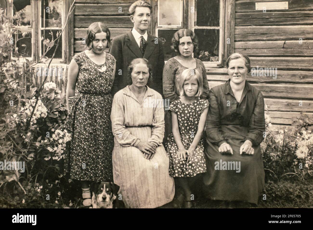 Latvia - CIRCA 1920s: Group portrait shot of five female and man outdoors next to entrance of country house. Vintage Art deco era photo Stock Photo