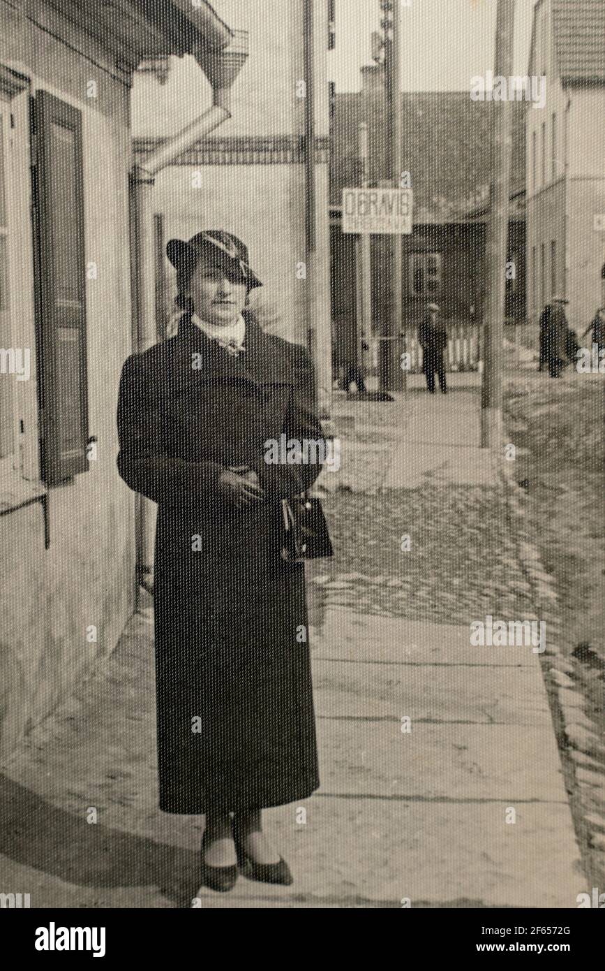 Germany - CIRCA 1930s: Lady wearing coat and hat portrait. Female standing on the street. Woman outdoors. Vintage Carte de Viste Art Deco era photo Stock Photo