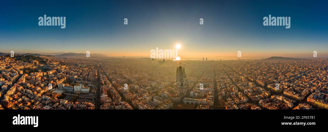 Aerial panorama drone shot of skyline in Barcelona city center in foggy sunrise golden hour in Spain winter Stock Photo