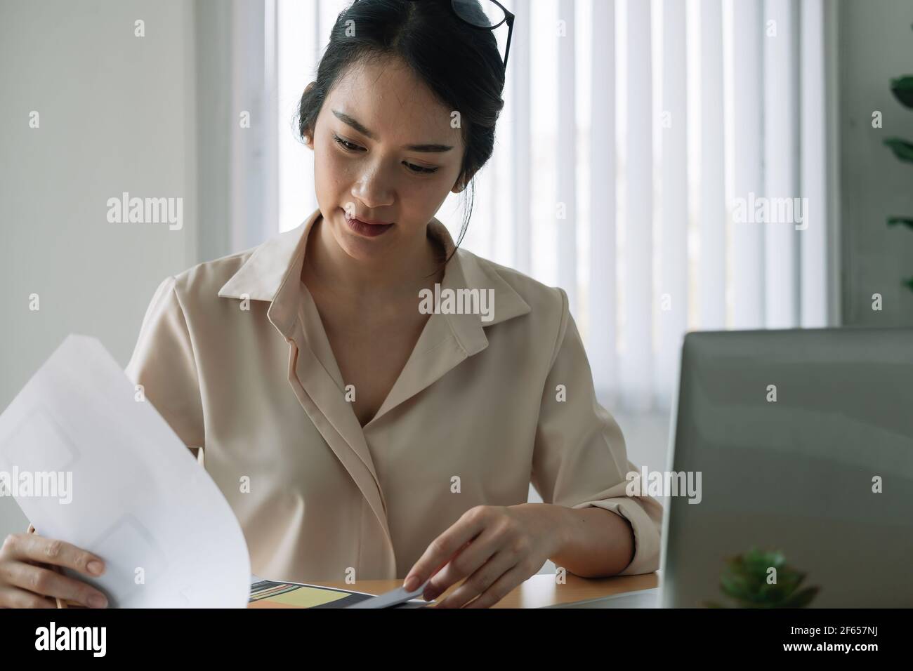 Female asian businesswoman analyzing the business report with laptop computer in the office. Stock Photo