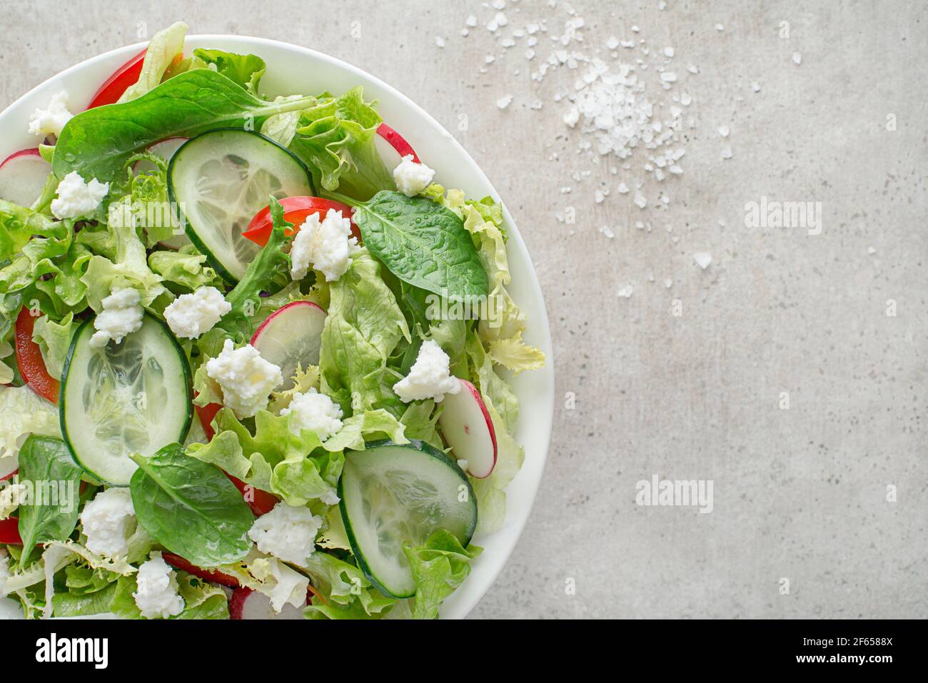 Lettuce salad with mixed vegetable and fresh cheese curd close up Stock Photo