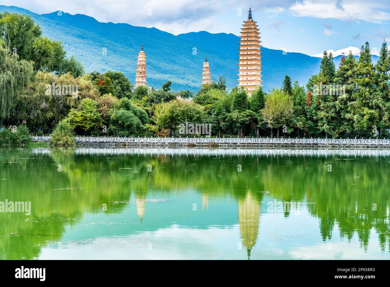 View of Dali Three Pagodas of Chongsheng Temple with water reflection and blue sky in Dali Yunnan China Stock Photo