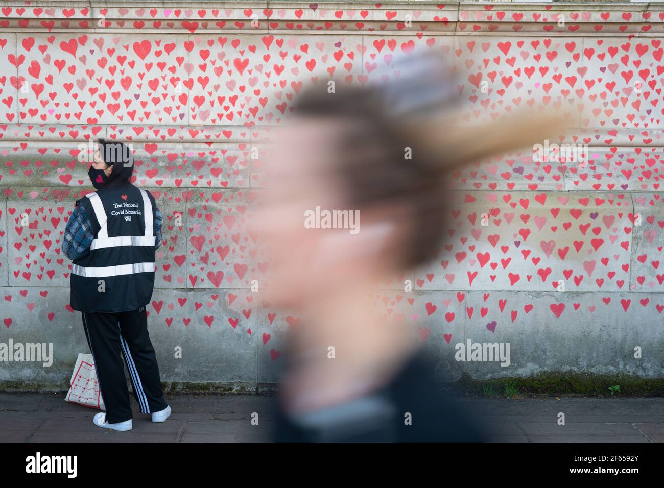 London, UK. 30th March, 2021. A memorial mural featuring nearly 150,000 red hearts C one for each UK covid death C will stretch for hundreds of metres, organised by the Covid-19 Bereaved Families for Justice group on the south bank of the Thames in London. Photo: Roger Garfield/Alamy Credit: Roger Garfield/Alamy Live News Stock Photo