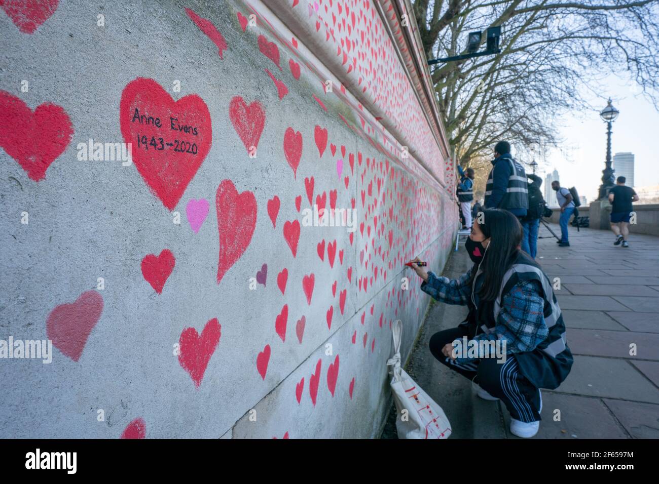 London, UK. 30th March, 2021. A memorial mural featuring nearly 150,000 red hearts C one for each UK covid death C will stretch for hundreds of metres, organised by the Covid-19 Bereaved Families for Justice group on the south bank of the Thames in London. Photo: Roger Garfield/Alamy Credit: Roger Garfield/Alamy Live News Stock Photo