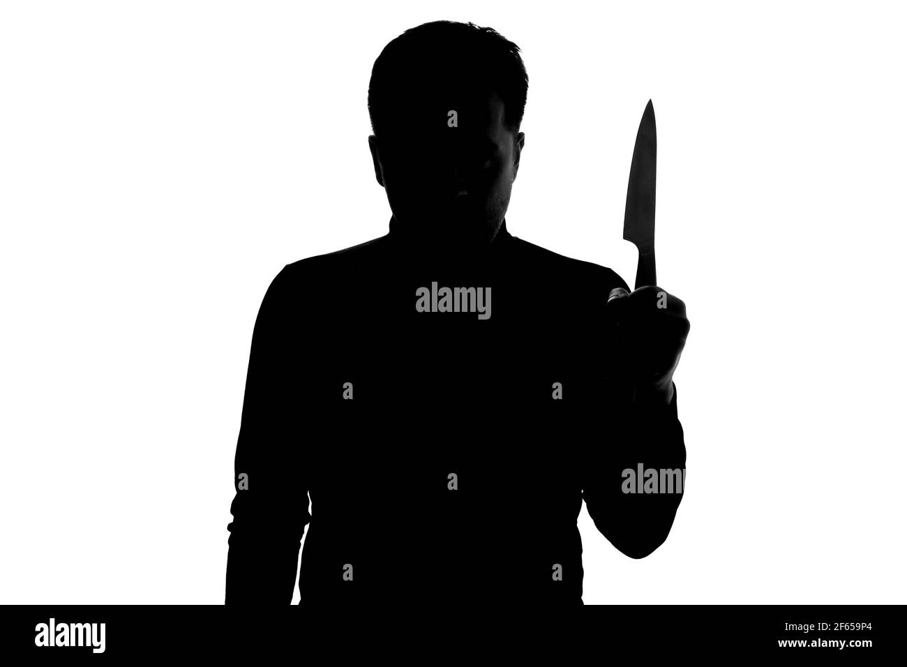 Silhouette of dangerous man with a knife in his hand being aggressive