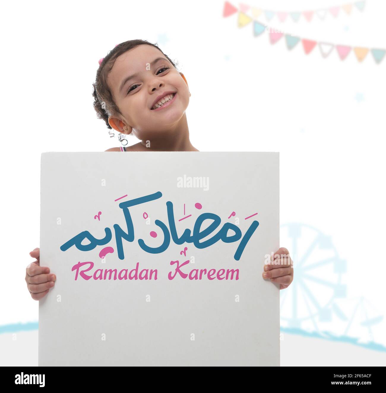 Happy Girl Holding Ramadan Greeting Board, Arabic Text Translation 'Holy Blessed Month of Ramadan' Stock Photo