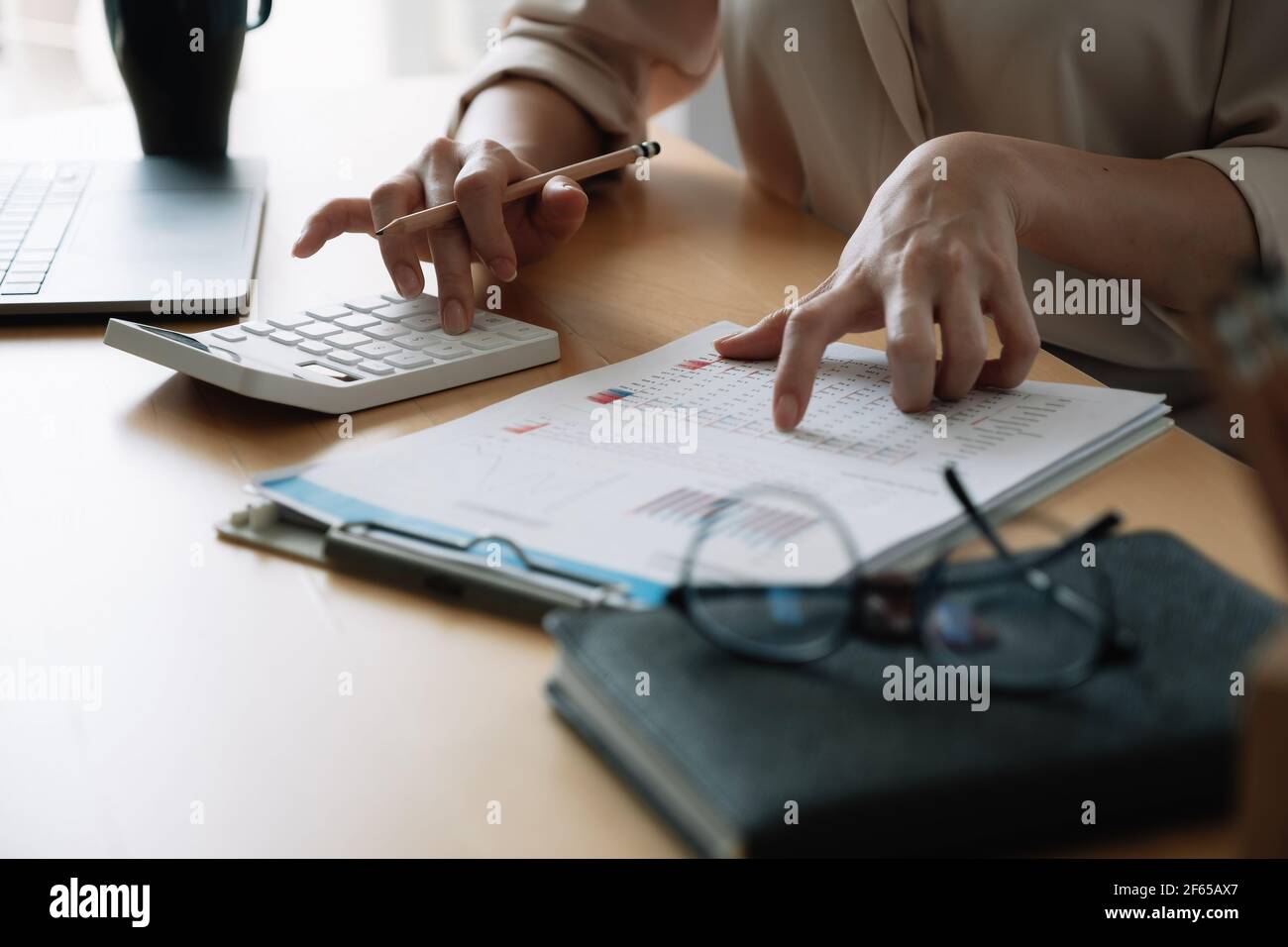 Close up Business woman or accountant using calculator with computer laptop, Business accounting, budget and loan paper at home Stock Photo