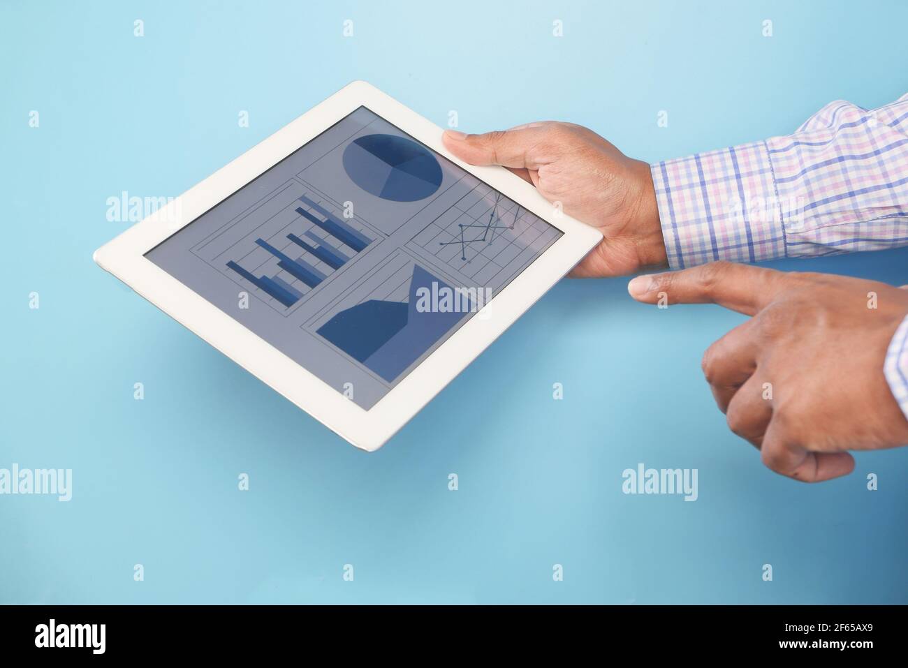 man's hand working on digital tablet against blue background  Stock Photo