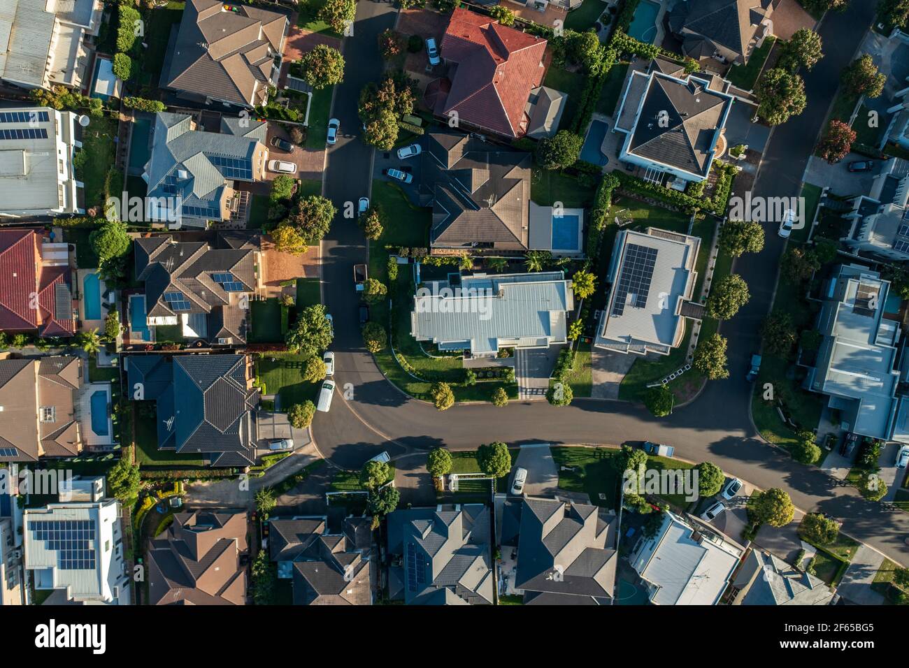Top down aerial view of an upmarket neighbourhood with street, houses, cars and gardens in north west Sydney, Australia. Stock Photo