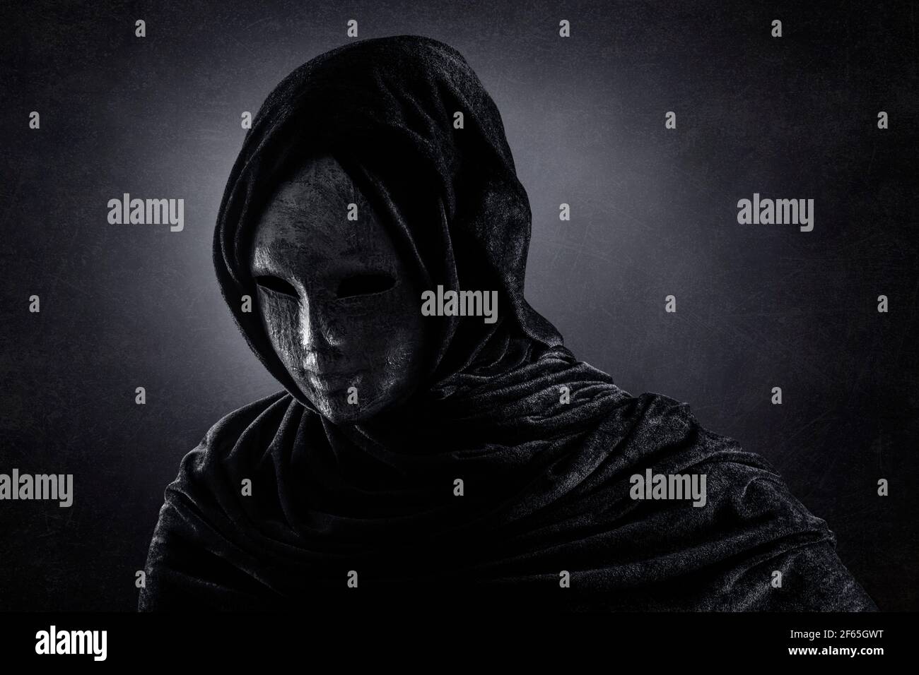 Scary figure with hooded cape in the dark Stock Photo - Alamy