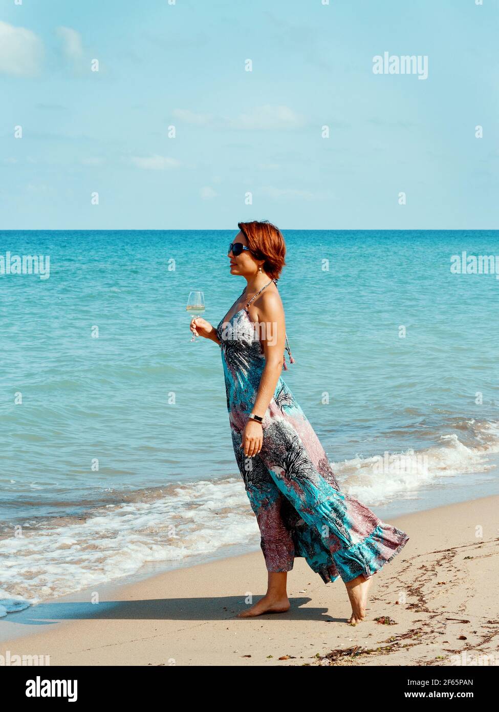 Young caucasian woman in a long dress with wine glass in hand walking on the beach Stock Photo - Alamy Young caucasian woman in a long dress with wine glass in hand walking on the beach Stock Photo - Alamy