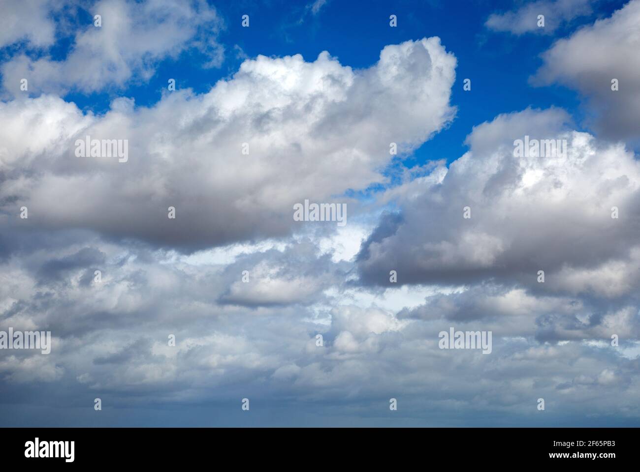 White fluffy cumulus clouds floating in blue sky above Shingle Street ...