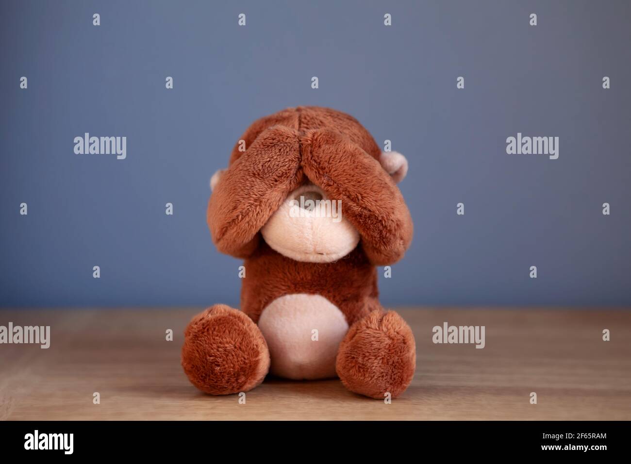 'See no evil' proverb with monkey teddy bear covering his eyes. Stock Photo