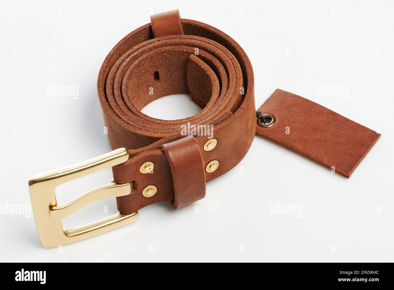 Roll of brown leather belt with tag perspective view isolated Stock Photo