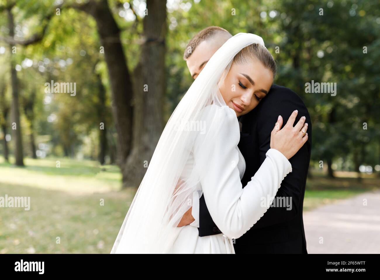 Groom hugs bride bouquet in hi-res stock photography and images - Alamy