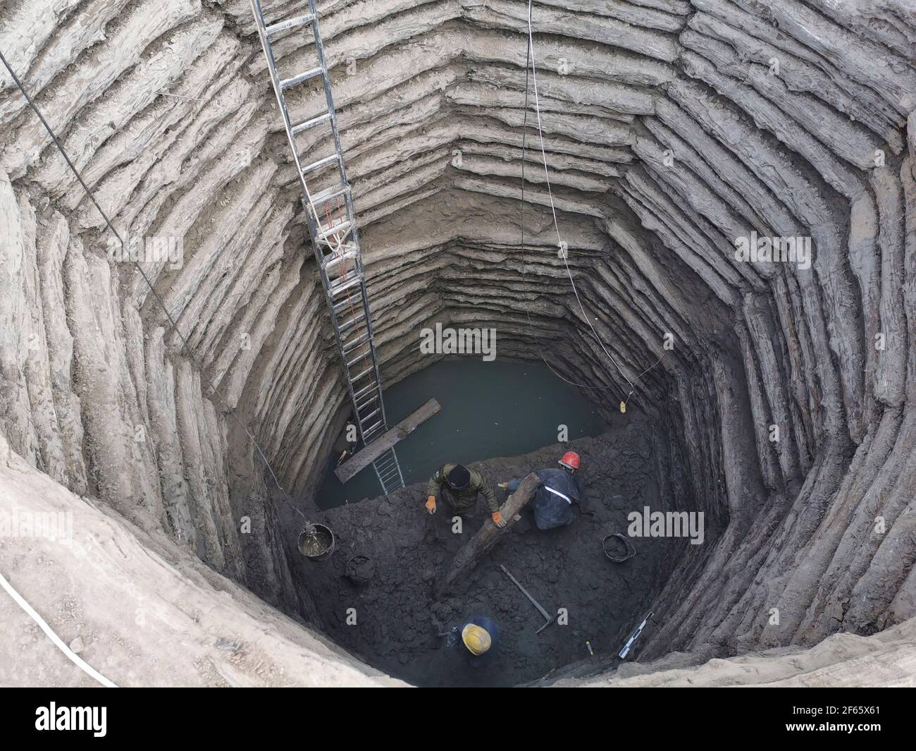 210330 taiyuan march 30 2021 xinhua file photo provided by the heritage management center in yangquan city of north chinas shanxi province shows researchers operating at the archaeological site of a 2000 year old well recently found in the province an ancient nine sided well bearing a wooden structure with a history of over 2000 years was discovered in north chinas shanxi province archaeologists announced tuesday heritage management center in yangquan cityhandout via xinhua 2F65X61