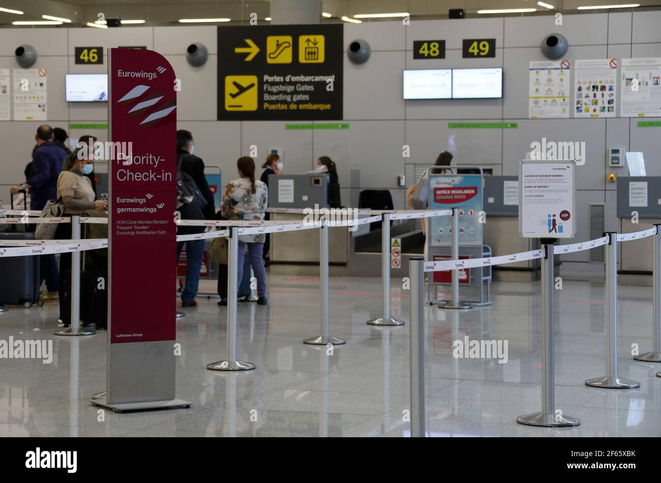 Palma De Mallorca, Spain. 30th Mar, 2021. People wait at the Eurowings check-in  at Palma airport. The new general testing requirement for all air travel to  Germany has not caused any major