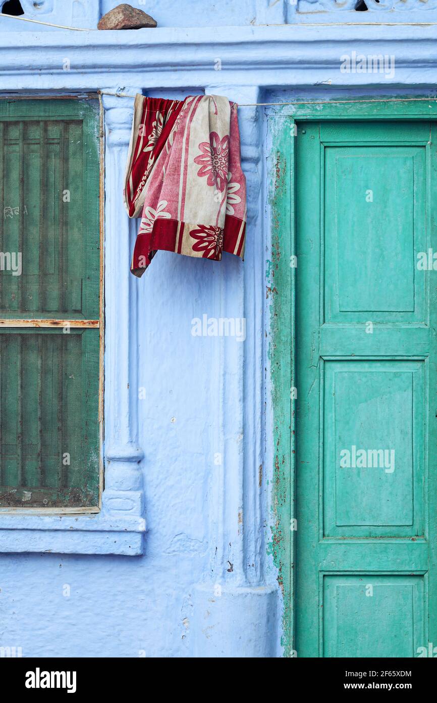 Red towel haning outside a house in the blue city of Jodhpur, India Stock Photo