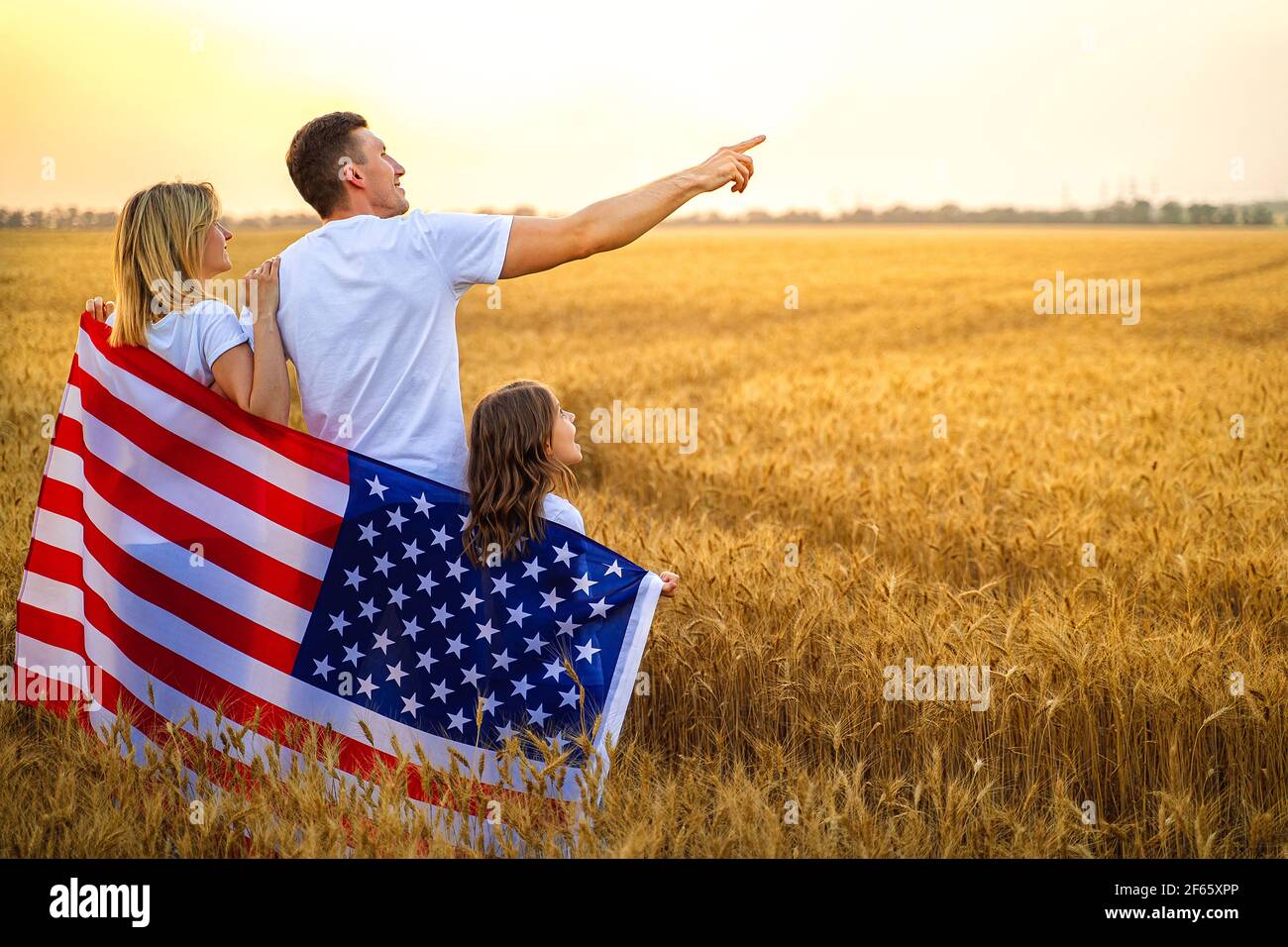 happy family with the flag of america USA at sunset outdoors  Stock Photo