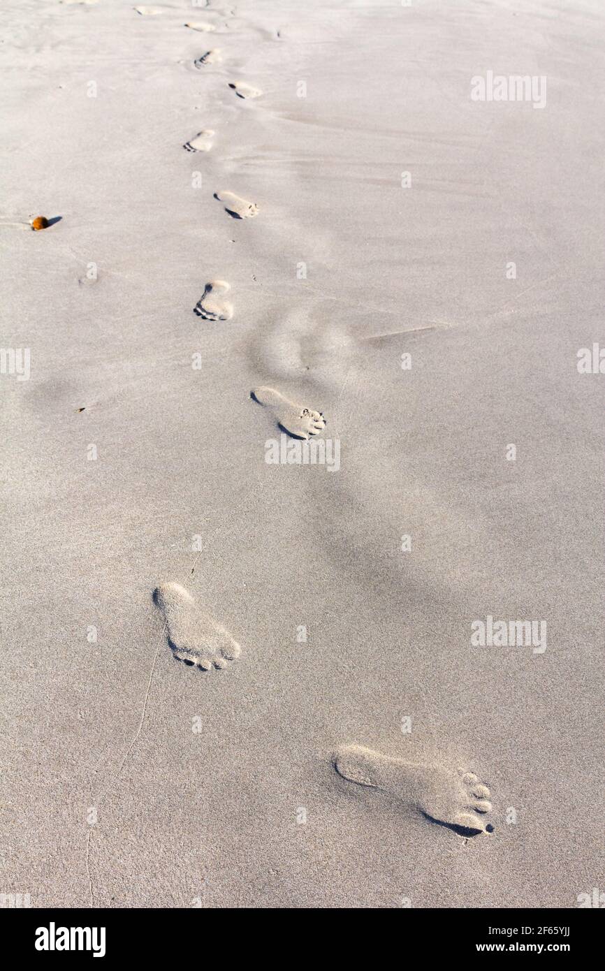 Footprints on white sand beach.Beautiful white sand background.Footprints background.Summer holiday and vacation. Stock Photo