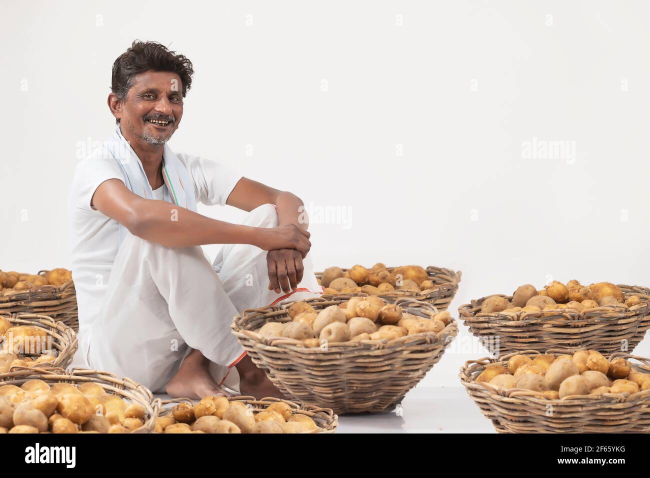 Indian Man harvesting potatoes with basket Stock Photo