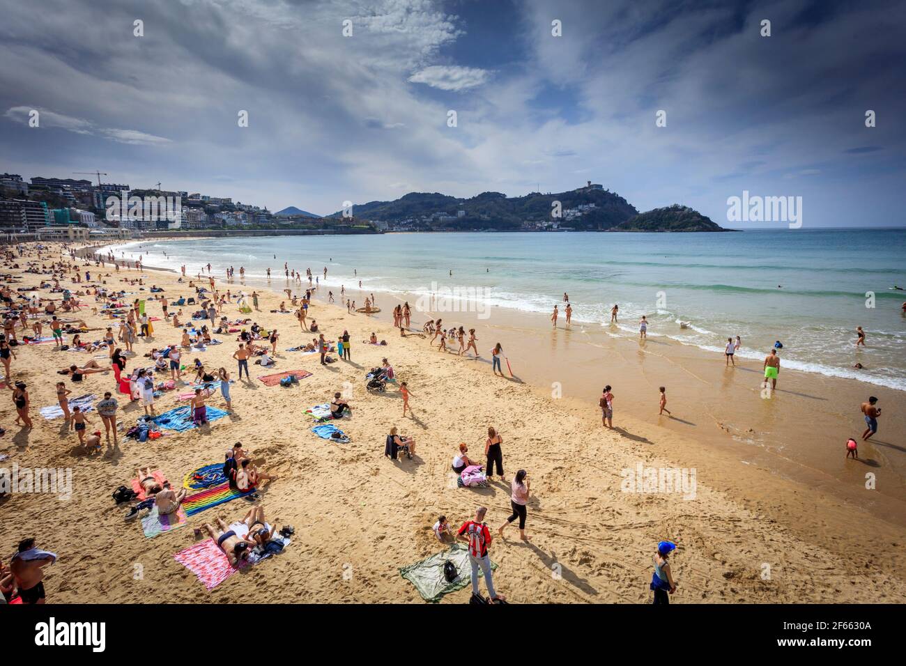 Sunbathers enjoy Easter Week on La Concha Beach in the seaside town of San Sebastian, Donostia, Basque country. Spain. Stock Photo