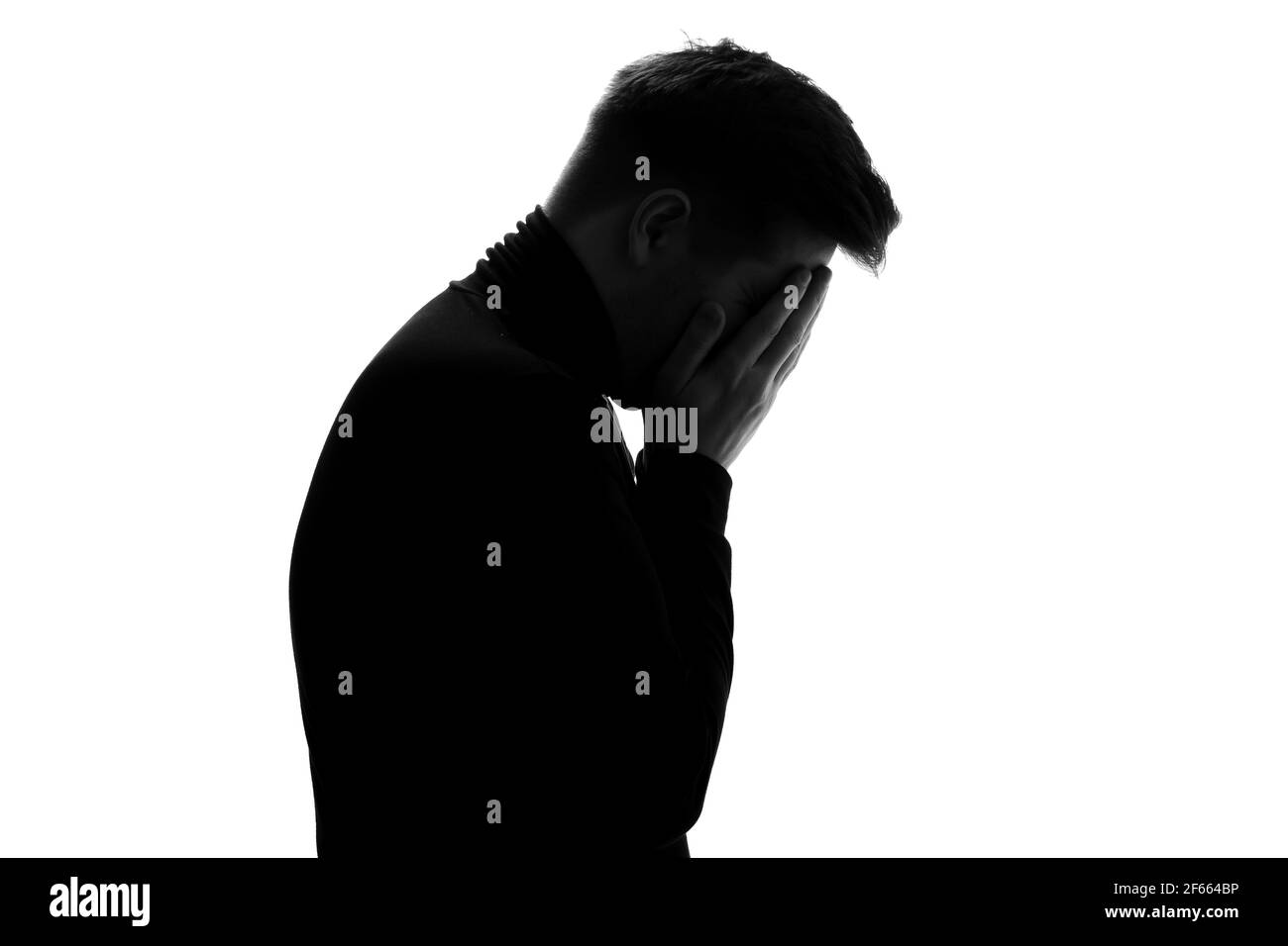 Silhouette of man crying being sad having depression. Studio shot Stock Photo