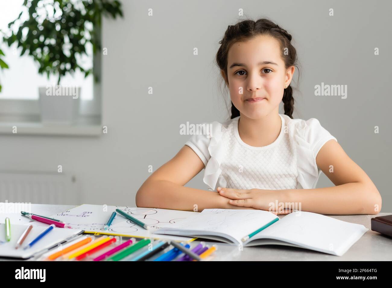 Cute little girl studying at home and smiling Stock Photo - Alamy