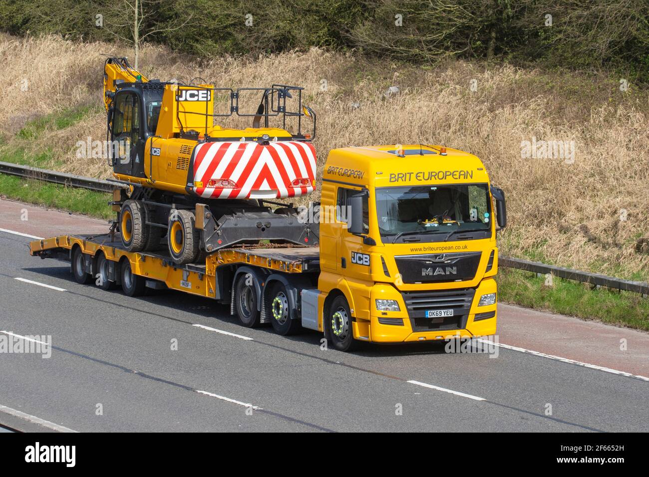 Brit European Transport Ltd; Haulage delivery trucks, JCB lorry, heavy-duty vehicles, transportation, truck, cargo carrier, Man vehicle, European commercial transport industry HGV, M6 at Manchester, UK Stock Photo