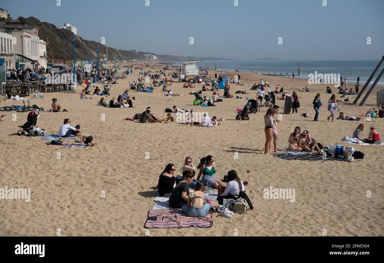 People enjoy the warm weather on Bournemouth beach in Dorset. Picture date: Tuesday March 30, 2021. Temperatures in parts of the UK are expected to be significantly warmer this week as families and friends are reunited and sporting activities are allowed to resume in England. Stock Photo