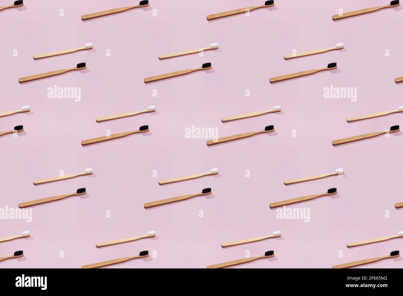 Pattern with wooden tooth brushes on pink background. Stock Photo