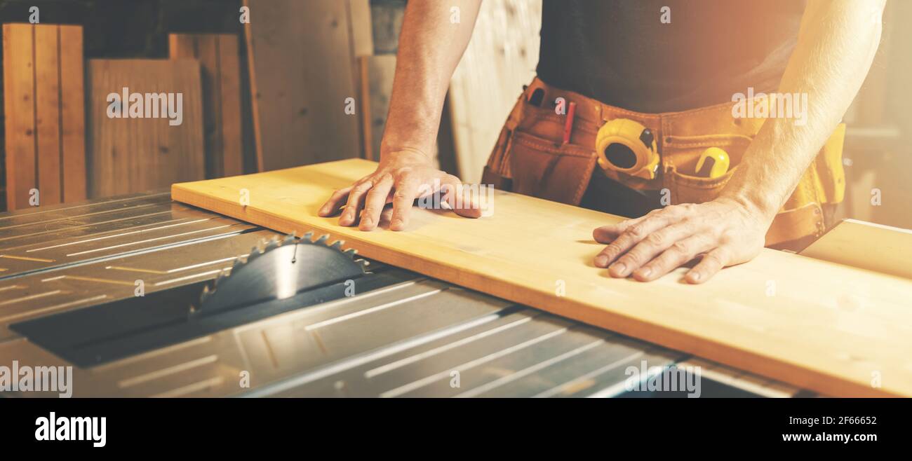 cutting wooden board on a table saw. woodworking and carpentry. furniture manufacturing Stock Photo