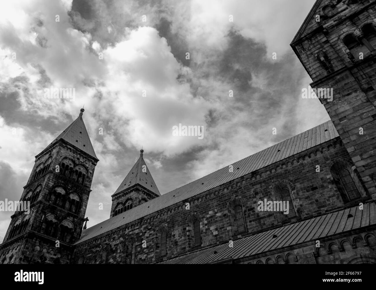 The south-eastern elevation of Lund Cathedral, Lund, Sweden, from the side, against a background of dramatic clouds. B&W Stock Photo
