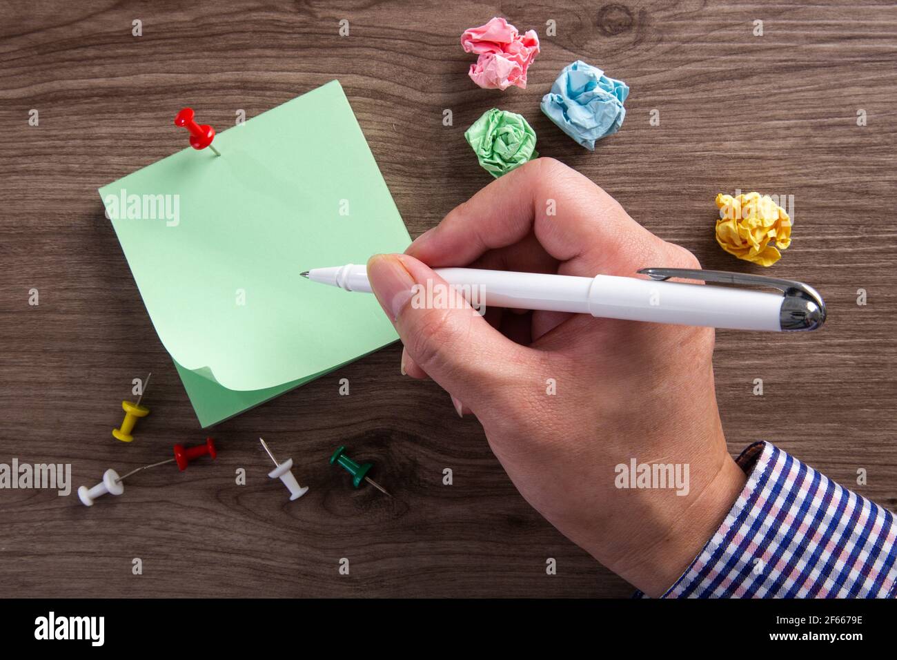 Close up of a hands writes on sticky note pad on a desk. Stock Photo