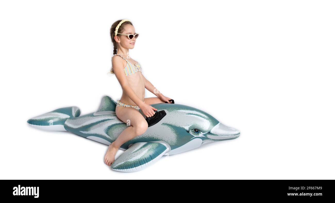 Happy child in a in a bathing suit on an inflatable dolphin. Coronavirus pandemic and healthy lifestyle concept. Stock Photo